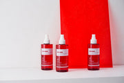 ProtoClinical k-beauty PAUL MEDISON Signature Body Mist 211ml #Baby Powder three translucent pink-red body mist bottles lined up on a white surface with a bright red rectangular backdrop