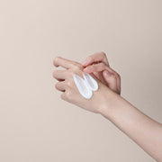 ProtoClinical k-beauty PAUL MEDISON Signature Perfume Collection Body Lotion 1600ml #White Musk close-up of a hand with two white lotion swatches being spread by the fingertips on a beige background