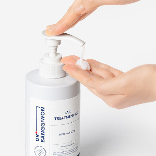 ProtoClinical k-beauty Dr.BANGGIWON LAB TREATMENT RX 480ml white pump bottle with cream spill on a vivid blue background and white pedestal