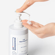 ProtoClinical k-beauty Dr.BANGGIWON LAB TREATMENT RX 480ml white pump bottle with cream spill on a vivid blue background and white pedestal