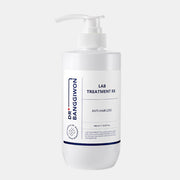 ProtoClinical k-beauty Dr.BANGGIWON LAB TREATMENT RX 480ml white pump bottle with cream spill on a vivid blue background and white pedestal