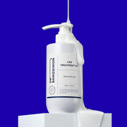 ProtoClinical k-beauty Dr.BANGGIWON LAB TREATMENT RX 480ml white pump bottle with cream spill on a vivid blue background and white pedestal