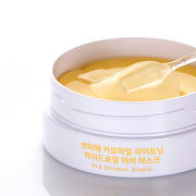 ProtoClinical k-beauty PETITFEE Chamomile Lightening Hydrogel Eye Mask 80g (60 Patches) single beige eye mask package laid horizontally on a soft blue and lavender background