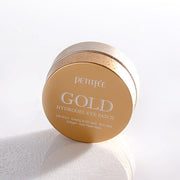 ProtoClinical k-beauty PETITFEE Gold Hydrogel Eye Patch (1.4g X 60 Patches) round amber brown jar centered on a pale blue background