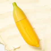 ProtoClinical k-beauty TONYMOLY Banana Hand Milk 45ml in a single yellow banana-shaped tube standing upright on a pale blue and cream background