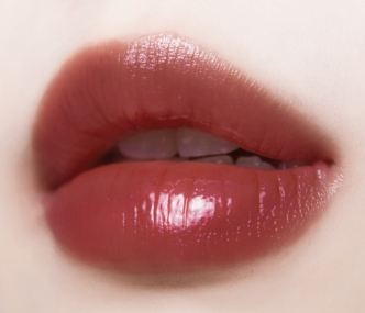 ProtoClinical k-beauty TONYMOLY Get it Tint Syrup Stick single nude-beige oval lip color swatch with a warm brown center on a pale background