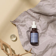 ProtoClinical k-beauty [MARY & MAY] 6 Peptide Complex Serum 30ml centered dark gray vertical silhouette with a warm beige left panel and muted mauve right side.