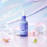 ProtoClinical k-beauty muted blue vertical beauty product silhouette centered on a pale blue background.