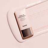 ProtoClinical k-beauty taupe beauty bottle silhouette with cool blue accents on a light background.
