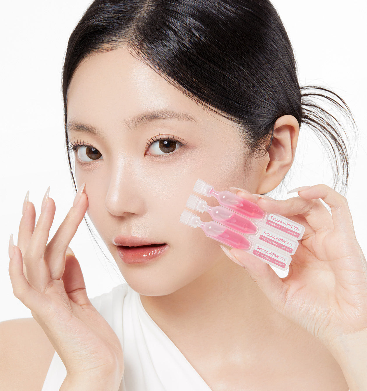 ProtoClinical k-beauty MEDICUBE: PDRN Pink One Day Serum 1box(1.5ml*) (10Units) model portrait holding three pink serum ampoules beside her cheek against a white background