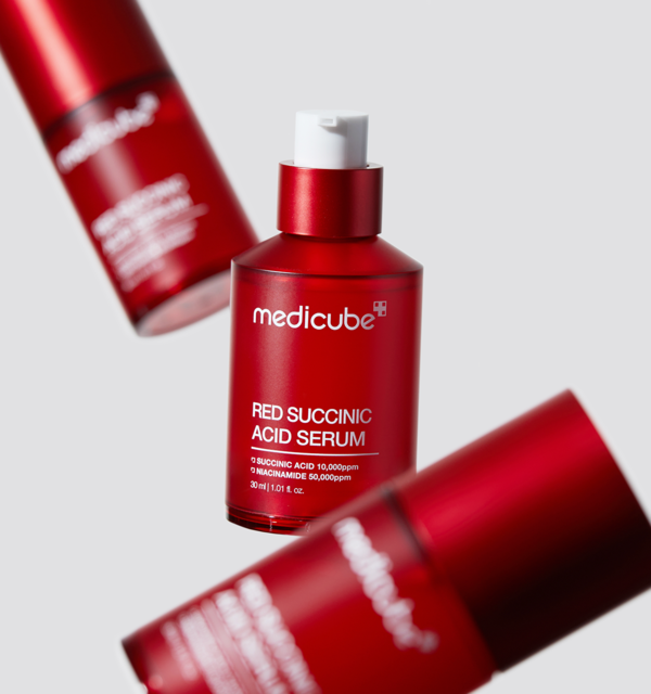 ProtoClinical k-beauty MEDICUBE: Red Succinic Acid Serum (30ml) single upright red serum bottle on a soft pink background with pale blue side accents