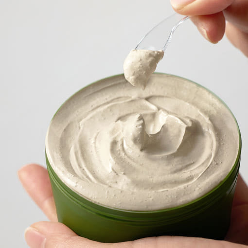 ProtoClinical k-beauty [SOME BY MI] Super Matcha Pore Clean Clay Mask 100g close-up of an open olive green jar with beige clay cream lifted on a clear spatula above the product