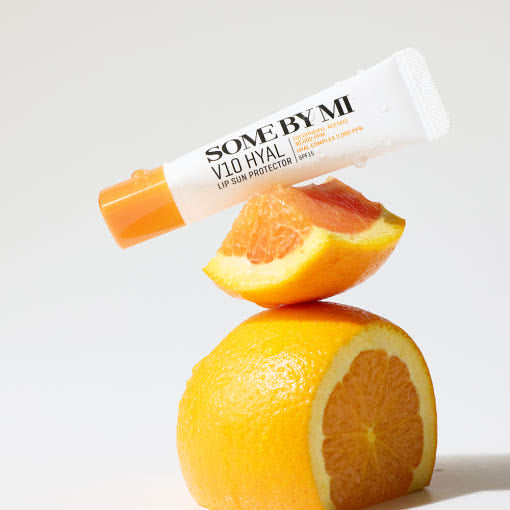 ProtoClinical k-beauty [SOME BY MI] V10 Hyal Lip Sun Protector 7ml single upright yellow lip sun protector tube centered on a pale blue and cream background