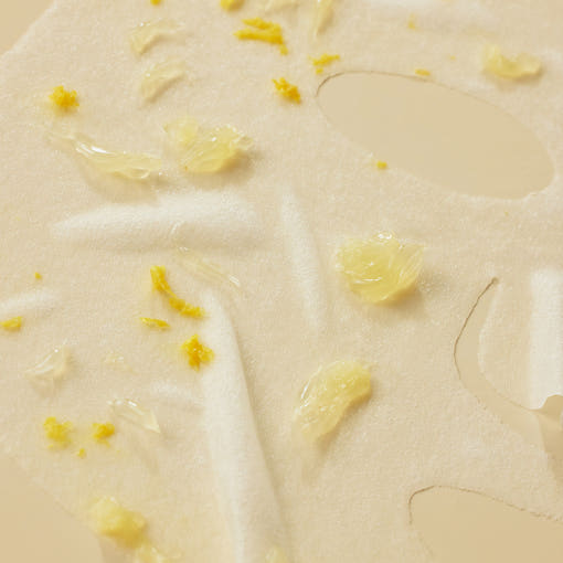 ProtoClinical k-beauty [SOME BY MI] Yuja Niacin Blemish Care Serum Mask 25g*10ea close-up of a white sheet mask with glossy essence and scattered yellow citrus pieces