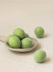 ProtoClinical k-beauty [Beauty of Joseon] Green Plum AHA BHA Toner 150ml green plums arranged on a shallow beige plate with one fruit set apart on a soft beige background