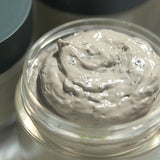 ProtoClinical k-beauty [Pyunkang Yul] Calming Pore Clear Wash Off Pack 100g open clear jar filled with gray clay mask texture beside a dark green lid on a soft background
