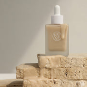 ProtoClinical k-beauty KAINE Chaga Collagen Charging Serum 30ml shown as a single upright beige serum package between cool gray and warm beige panels
