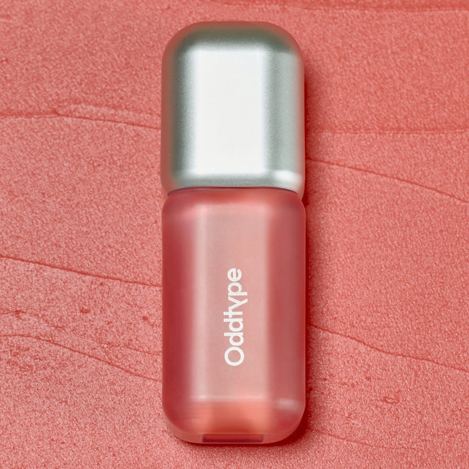 ProtoClinical k-beauty Oddtype Unseen Blur Tint (562, 655, 788) single upright lip tint tube centered on a coral pink background