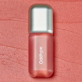ProtoClinical k-beauty Oddtype Unseen Blur Tint (562, 655, 788) single upright lip tint tube centered on a coral pink background