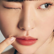 ProtoClinical k-beauty Oddtype Unseen Blur Tint (562, 655, 788) single upright peach lip tint tube centered on a warm beige and taupe background