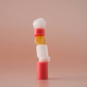 ProtoClinical k-beauty [MACQUEEN New York] Better Than Kiss Lip Balm 3.5g (3-type) stacked peach, yellow, and white balm sticks arranged diagonally on a pastel pink background