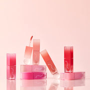 ProtoClinical k-beauty [MACQUEEN New York] Dewy Over Lip Gloss (6 Colors) single pink lip gloss swatch in a wide horizontal band on a warm cream and pale yellow background