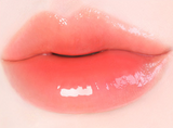 ProtoClinical k-beauty [MACQUEEN New York] Dewy Water Glow Lip Tint 3.5g (9 Color) single warm coral lip tint swatch in a rounded teardrop shape on a pale blue and mint background