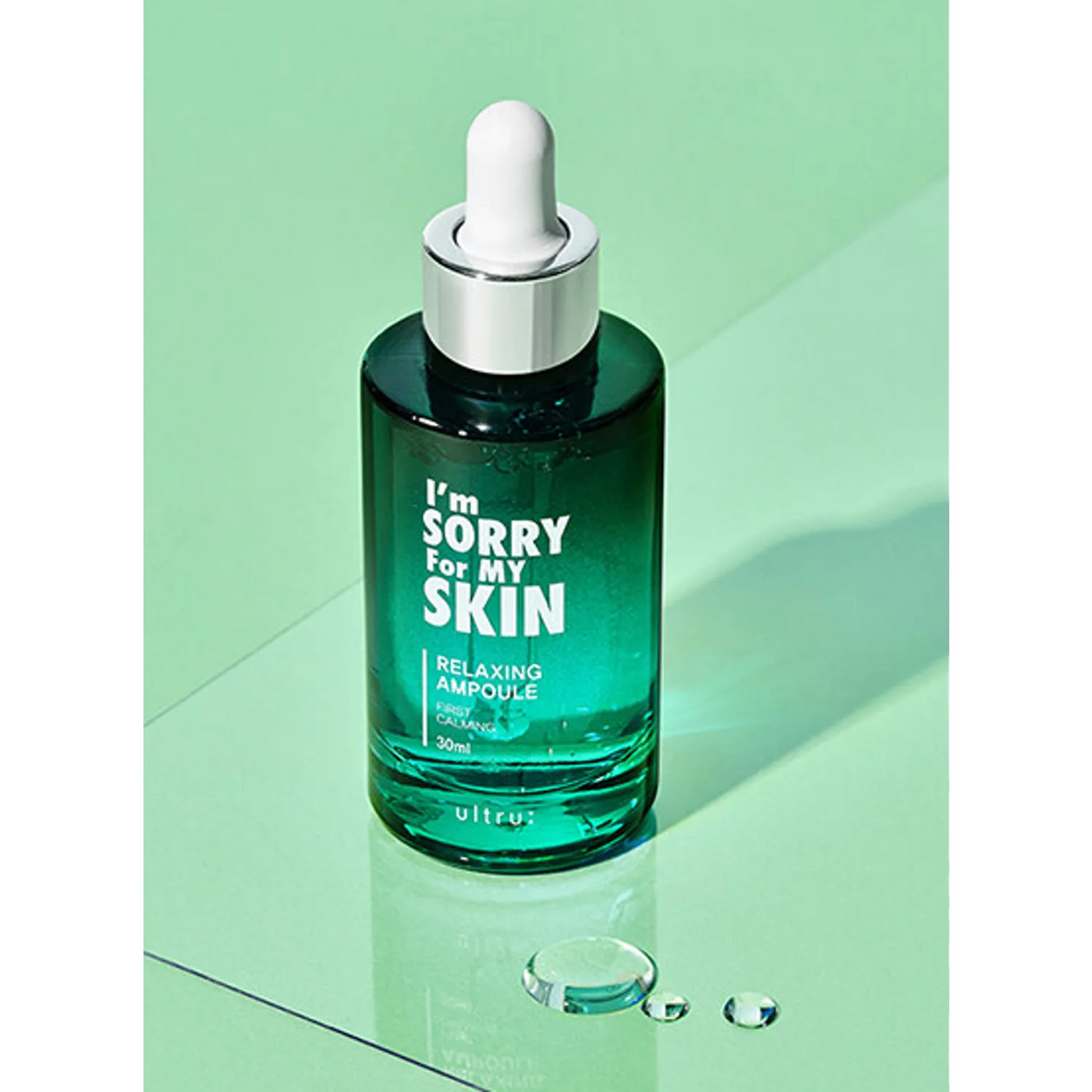 ProtoClinical k-beauty [I'm Sorry For My Skin] Relaxing Ampoule 30ml teal glass dropper bottle standing upright on a mint green reflective surface with visible water droplets