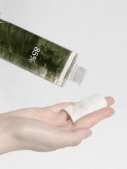 ProtoClinical k-beauty blurred olive and beige beauty graphic with a dark horizontal band, soft blush tones, and pale side highlights on a light background.