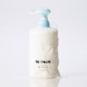 ProtoClinical k-beauty product packaging with a tall pale bottle silhouette on a soft light background.
