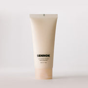 ProtoClinical k-beauty SENNOK Shiny Everyday Treatment Soap Clean Soap 180ml product image with a soft beige vertical bottle silhouette and pale blue side accents on a light background.