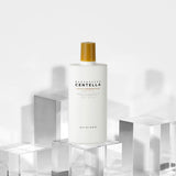 ProtoClinical k-beauty SKIN1004: Madagascar Centella Air-fit Suncream Plus Spf50+ Pa (50ml) single pale cream package silhouette with soft green and blue side accents on a light background.