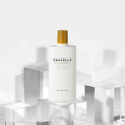 ProtoClinical k-beauty SKIN1004: Madagascar Centella Air-fit Suncream Plus Spf50+ Pa (50ml) single pale cream package silhouette with soft green and blue side accents on a light background.