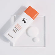 ProtoClinical k-beauty Dr.Ceuracle 5α Control No Sebum Sun Lotion SPF50+ PA++++ 50ml white sun lotion bottle with an orange cap laid diagonally on a white tray with circular white props