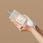 ProtoClinical k-beauty abstract sage, beige, and cream skincare graphic with soft blurred vertical forms on a light background.