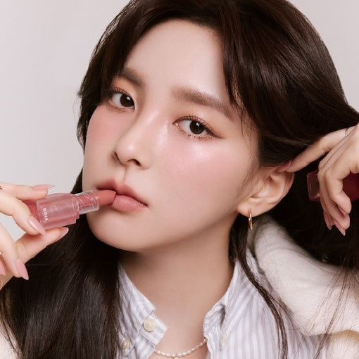 ProtoClinical k-beauty BBIA Last Powder Lipstick 3.5g model portrait holding a rosy nude lipstick to her lips against a soft beige background