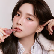 ProtoClinical k-beauty BBIA Last Powder Lipstick 3.5g model portrait holding a rosy nude lipstick to her lips against a soft beige background