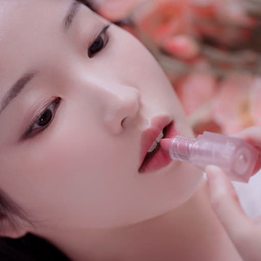 ProtoClinical k-beauty BBIA Last Powder Lipstick 3.5g model portrait holding a rosy nude lipstick to her lips against a soft beige background