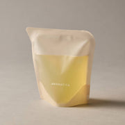 ProtoClinical k-beauty AROMATICA Zesty Hand Soap Grapefruit & Tangerine 300ml (Refill) single upright pale yellow hand soap refill package centered on a warm gray background.