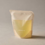 ProtoClinical k-beauty AROMATICA Zesty Hand Soap Grapefruit & Tangerine 300ml (Refill) single upright pale yellow hand soap refill package centered on a warm gray background.