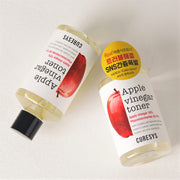 ProtoClinical k-beauty CURESYS Apple Vinegar Toner 300ml single upright toner bottle with a gray center panel and pale yellow upper tones on a light background