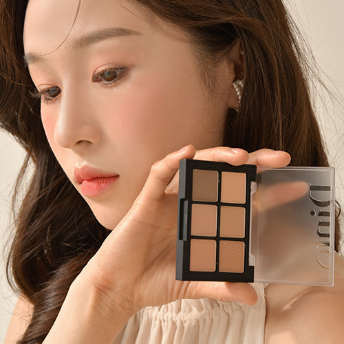 ProtoClinical k-beauty Dinto Blur-Finish Shadow 5.4g #702 Jelda Fitzgerald woman holding the open six-pan palette beside her face with warm nude eye makeup