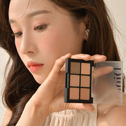 ProtoClinical k-beauty Dinto Blur-Finish Shadow 5.4g #702 Jelda Fitzgerald woman holding the open six-pan palette beside her face with warm nude eye makeup