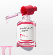 ProtoClinical k-beauty MEDICUBE: Txa Niacinamide 15% Serum (30ml) single upright pale pink serum bottle centered on a light background with soft blue side accents