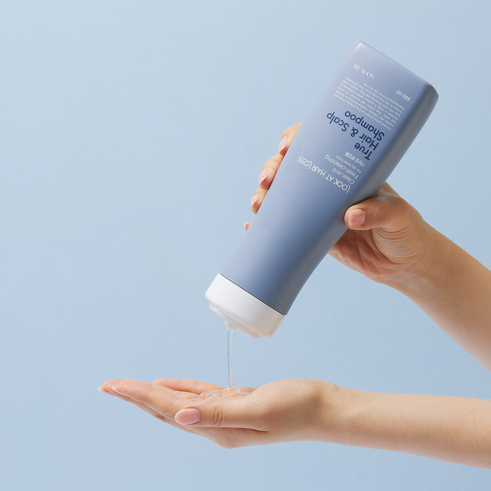 ProtoClinical k-beauty [Daeng Gi Meo Ri] Look At Hair Loss True Hair & Scalp Shampoo 500ml shown as an abstract graphic with a pale blue background, a blurred charcoal vertical shape on the right, and a soft mauve area across the lower right
