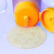 ProtoClinical k-beauty NEOGEN Dermalogy Double Vita Capsule Cleansing Foam 160g with an orange flip cap dispensing clear gel dotted with yellow and orange capsules on a pale blue background