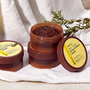 ProtoClinical k-beauty NEOGEN Dermalogy Real Polish - Royal Honey & Sugar Scrub 100g in an open amber-brown jar filled with brown scrub, with the round lid propped behind on a pale background