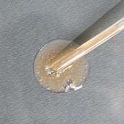 ProtoClinical k-beauty warm beige beauty product detail with soft gray tones on a light background.
