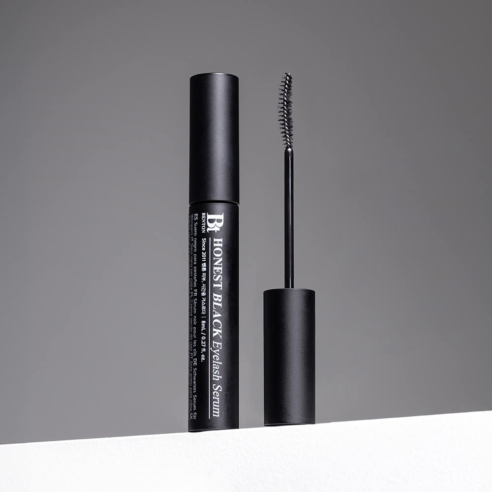 ProtoClinical k-beauty Benton Honest Black Eyelash Serum 8ml model portrait holding the black eyelash serum tube against a soft gray background