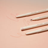 ProtoClinical k-beauty [TOO COOL FOR SCHOOL] Artclass Glam Under Liner 0.2g/0.7g (4 Colors) four cream liner pens laid diagonally on a peach background with one fine brush tip, two beige pencil tips, and soft swatch marks